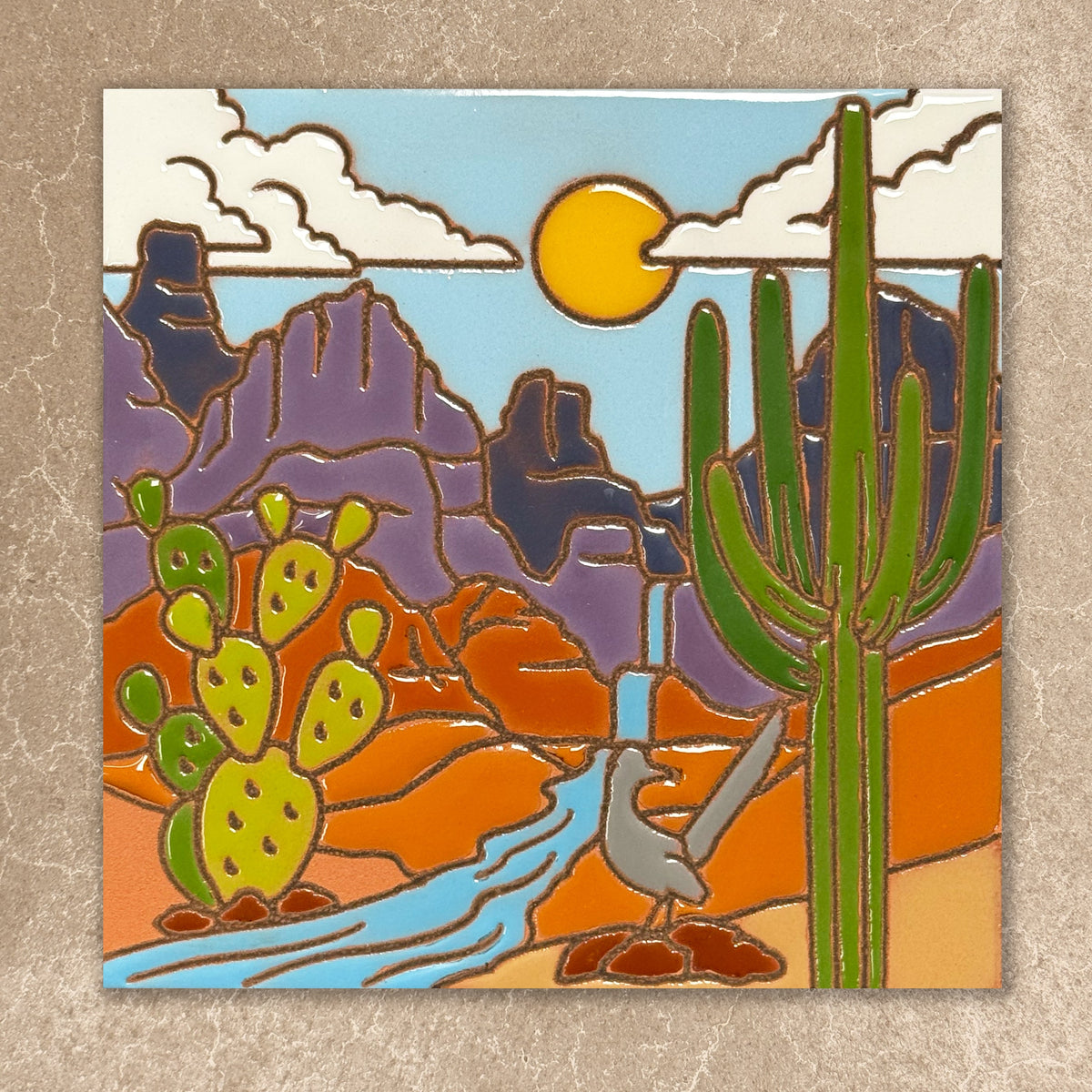 Stylized desert scene with cacti, mountains, and a bird on a textured beige background ceramic tile