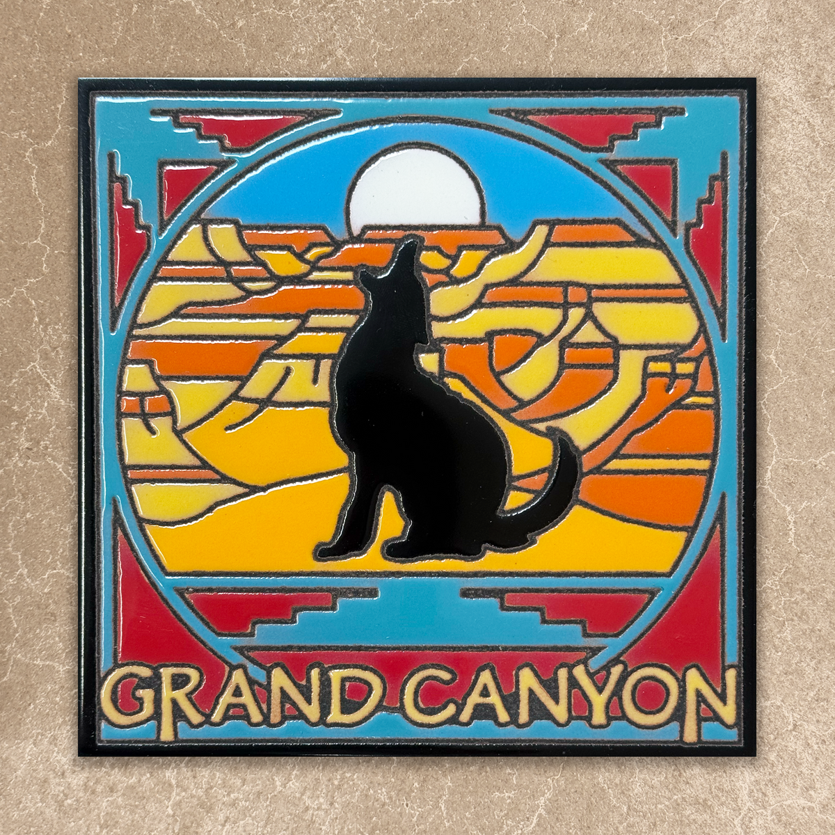 Decorative tile with a coyote silhouette and Grand Canyon design on a beige background