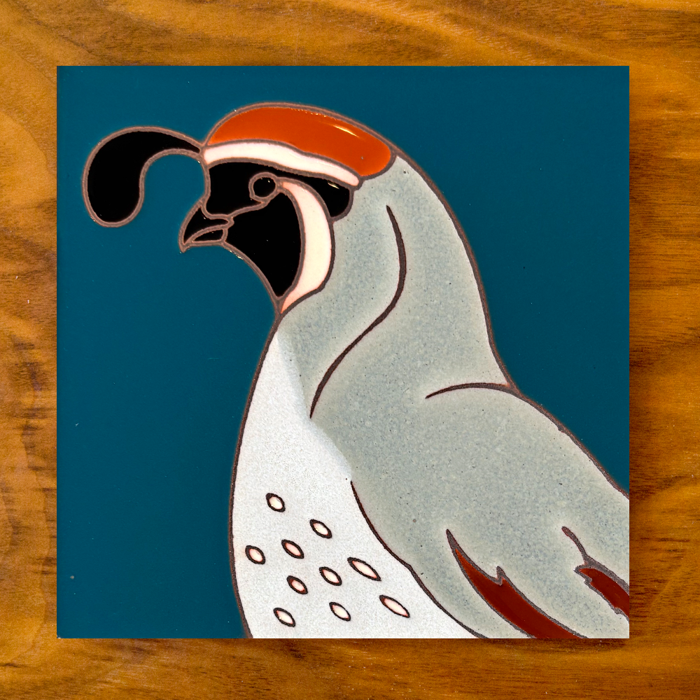 owl ceramic tile coaster on a blue background with wood table