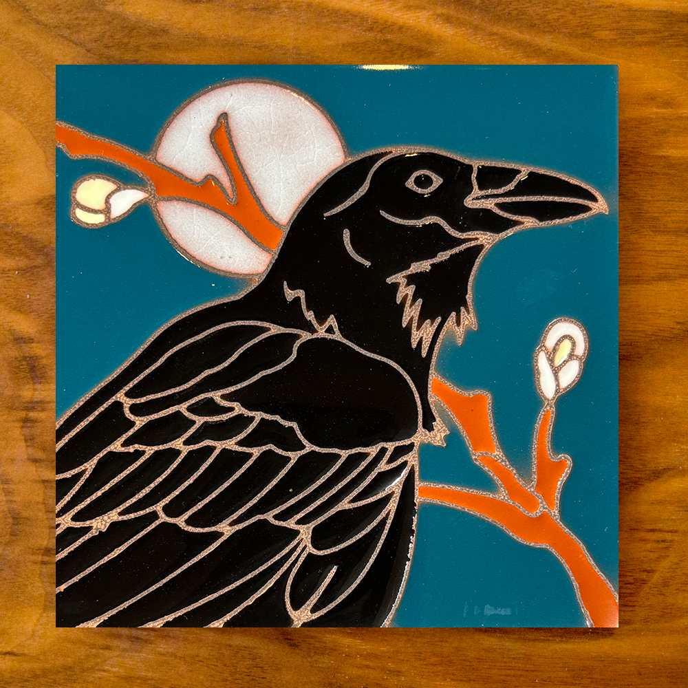 owl ceramic tile coaster on a blue background with wood table