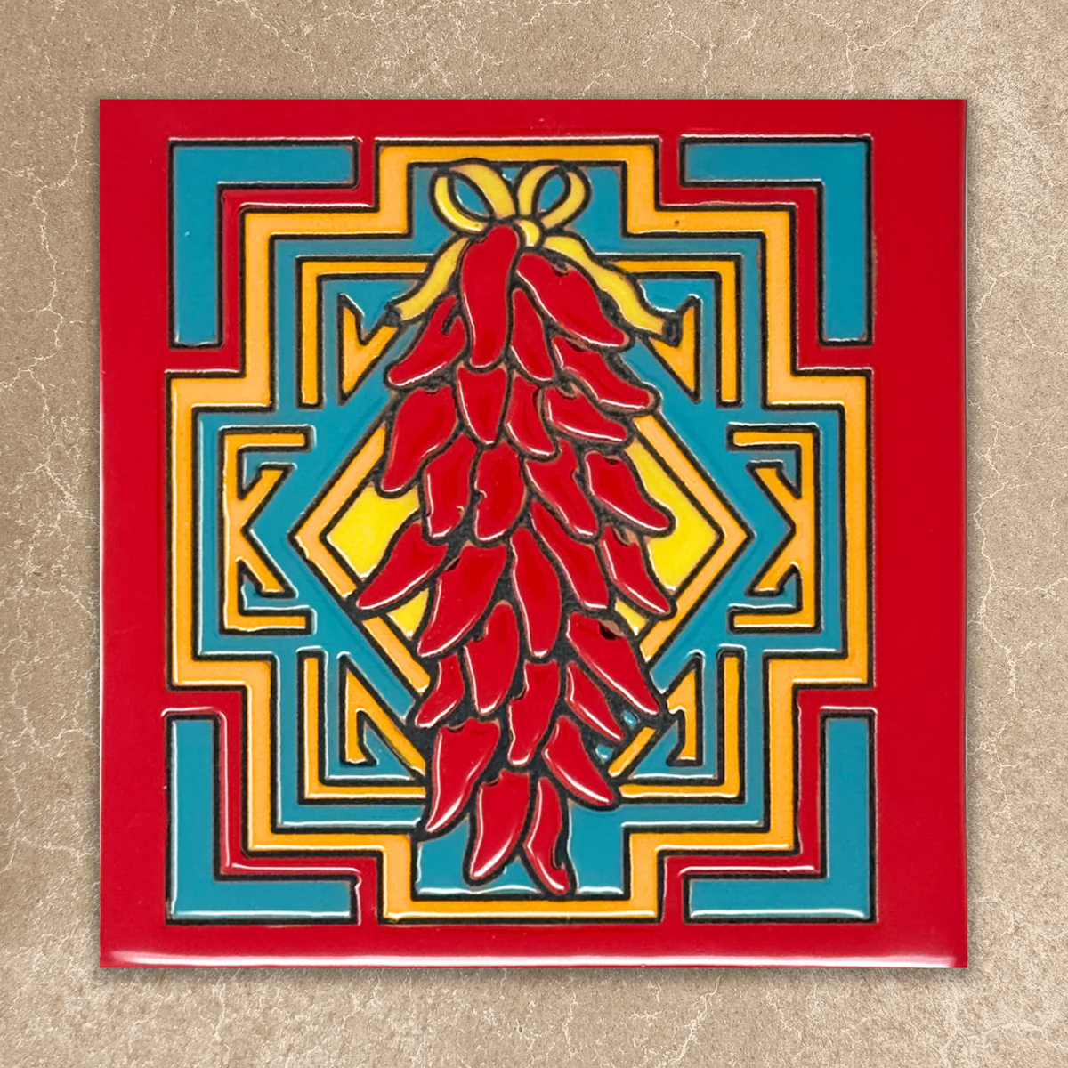 Decorative tile with red chili peppers and geometric pattern on a beige background