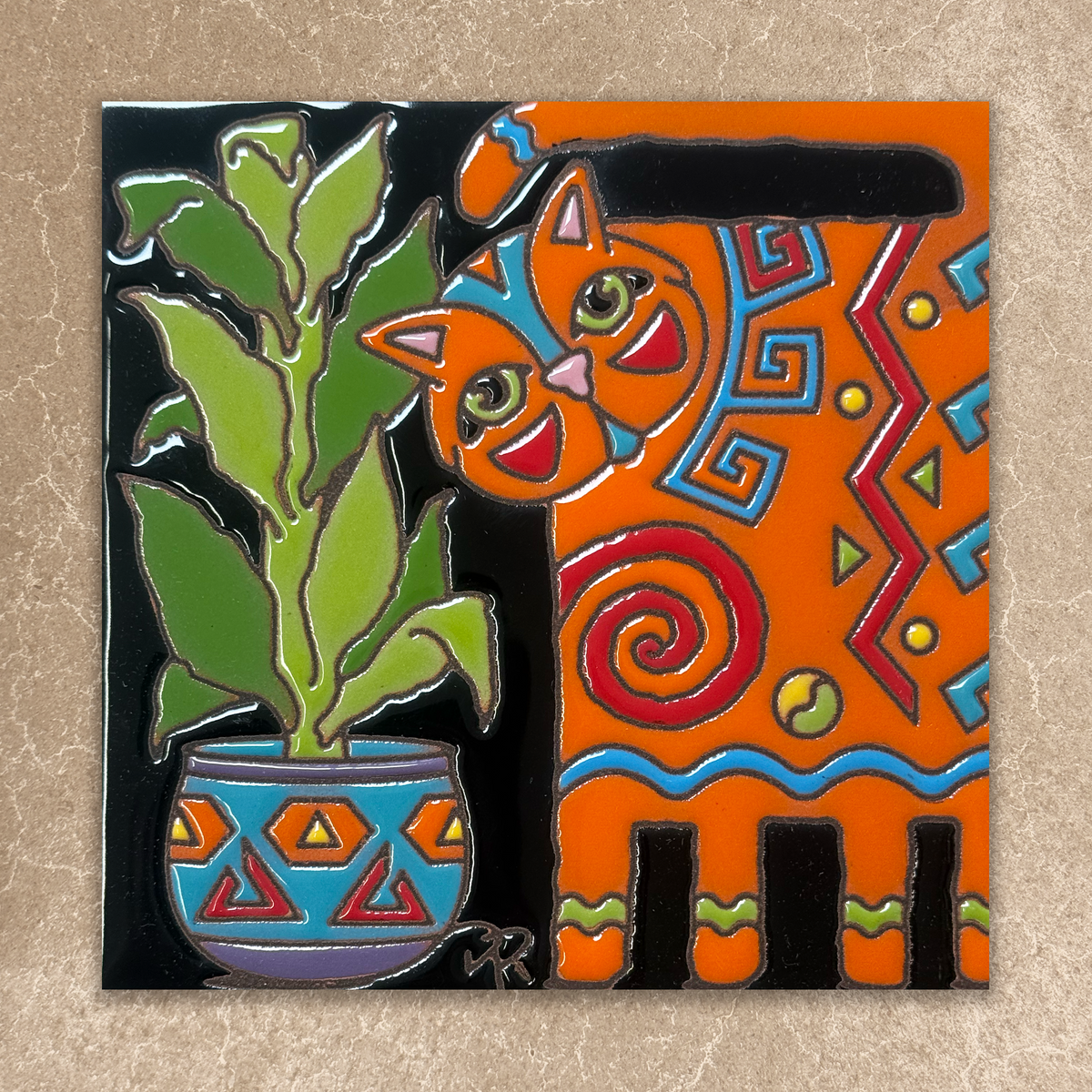 Colorful ceramic tile with a cat and plant design on a beige background