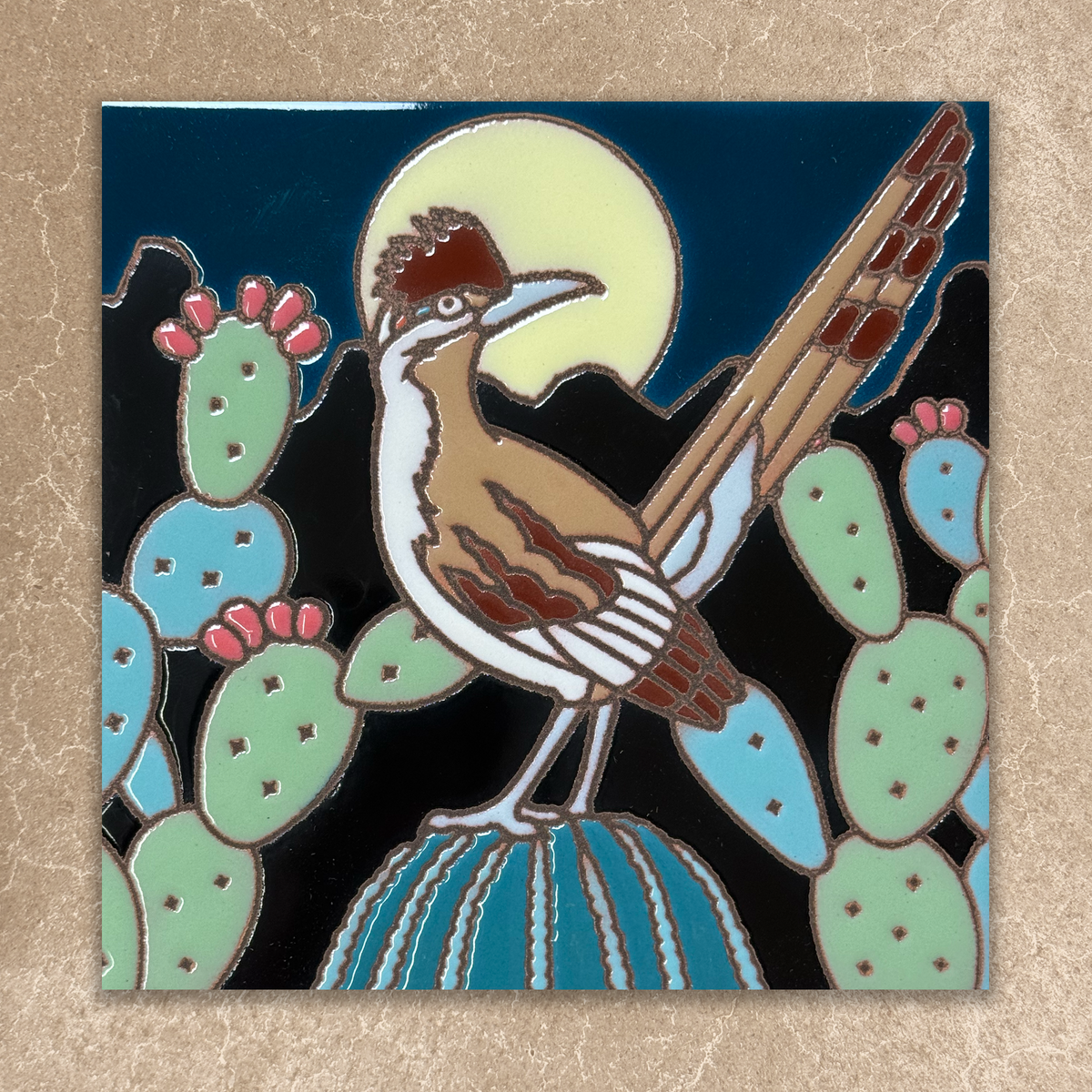 ceramic tile with a roadrunner bird design on a beige background
