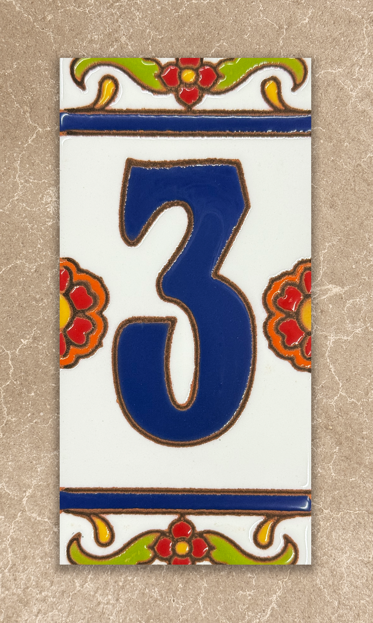 Decorative tile with the number '3' in blue, surrounded by floral designs on a beige background