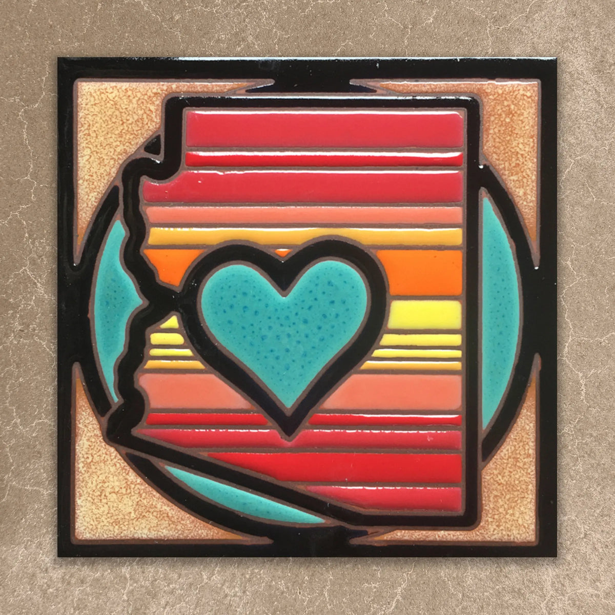 Colorful  tile with a black border on a textured beige background