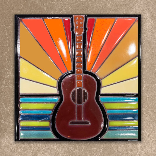 Colorful guitar-shaped object with a sunburst pattern on a beige background