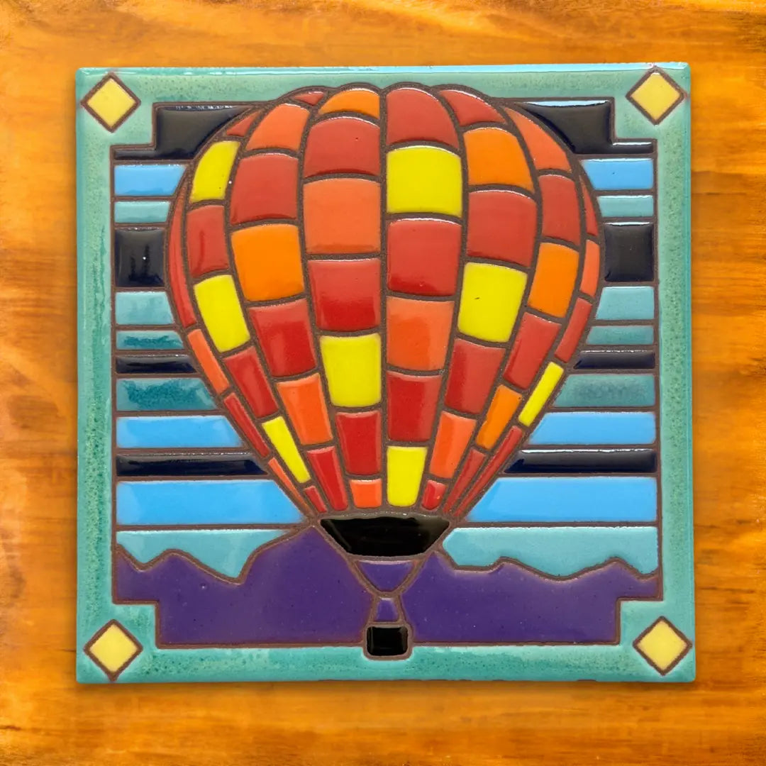 Mosaic hot air balloon art piece on a wooden background
