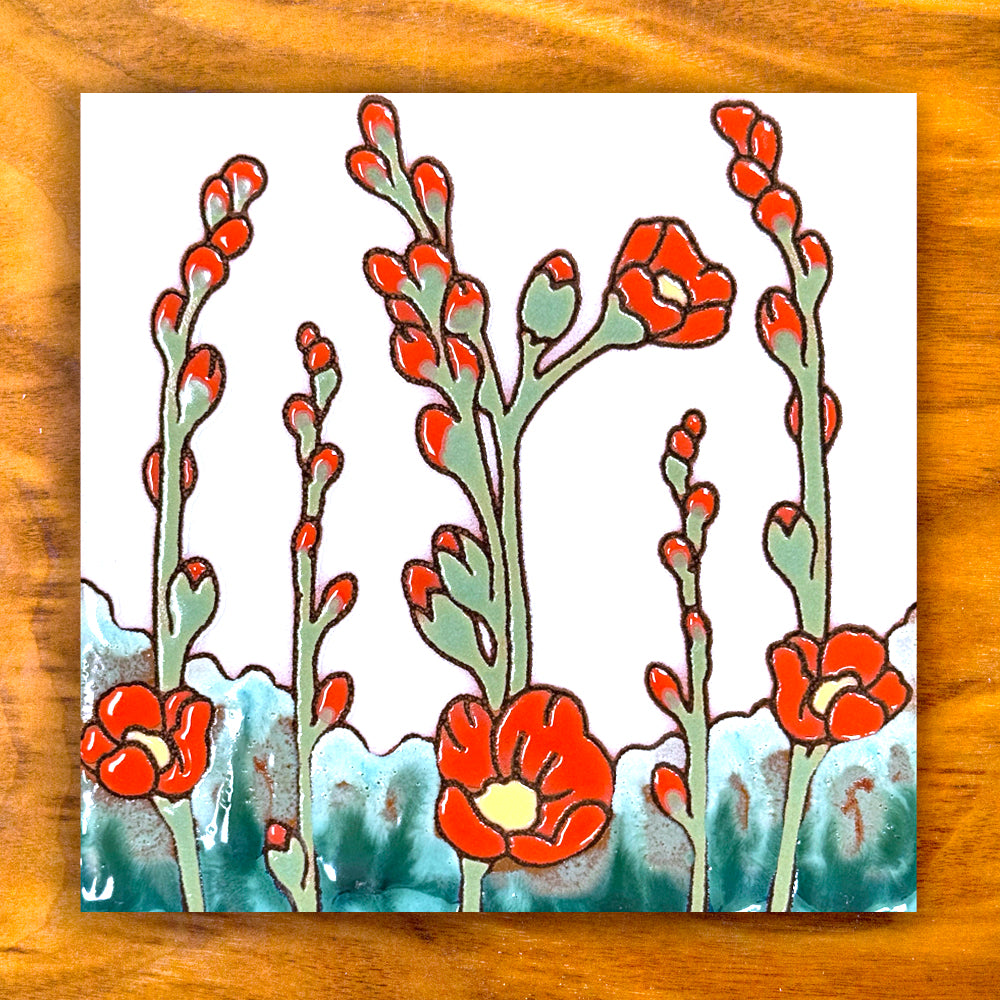 Decorative tile with red floral design on a wooden surface