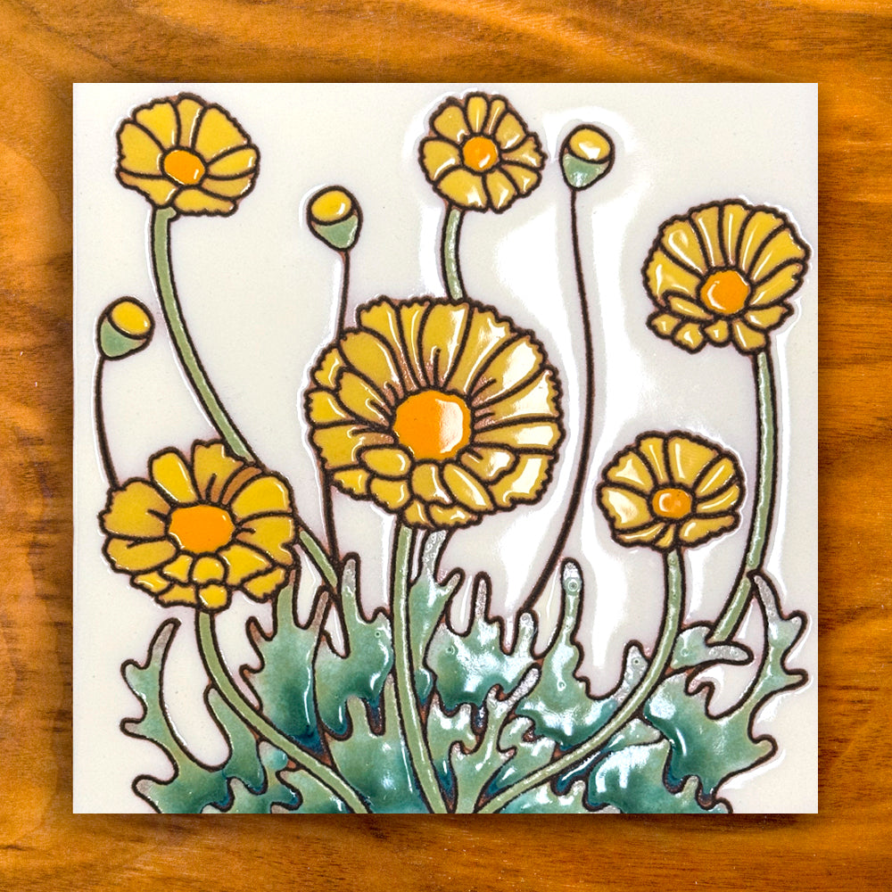 Decorative tile with yellow flowers on a wooden surface