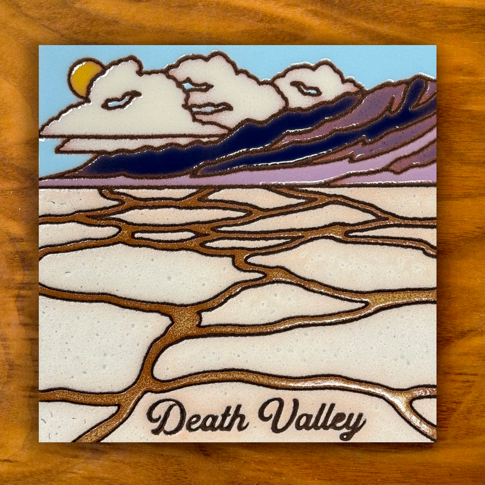 ceramic tile depicting badwater basin with death valley text on a wooden background