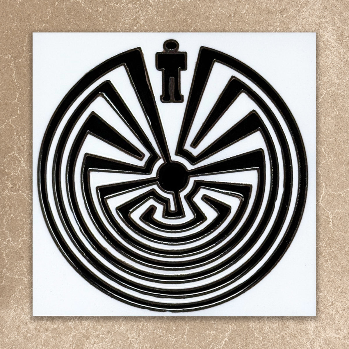 Black and white circular maze design on a beige background
