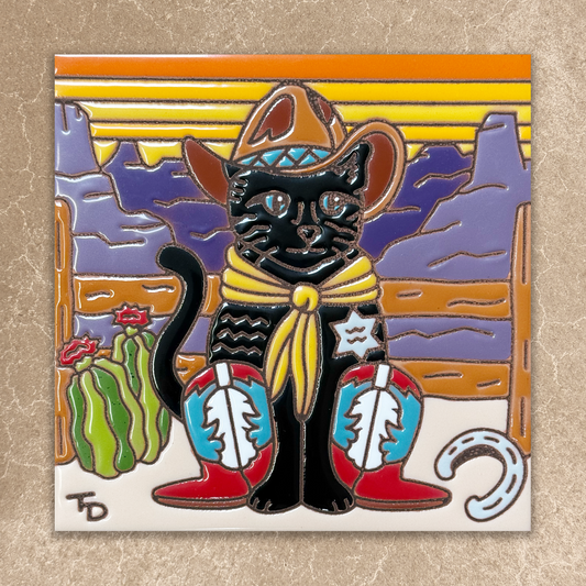 A square ceramic tile or coaster featuring a colorful western-themed illustration of a black cat wearing a cowboy hat, yellow bandana, boots, and a star badge, set against a desert landscape with a cactus and mountains.