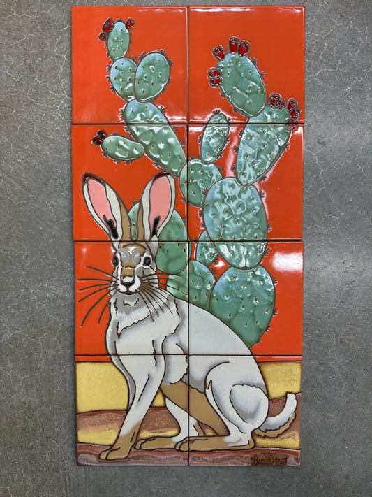 Decorative tile mural with a rabbit and cactus design on an orange background.