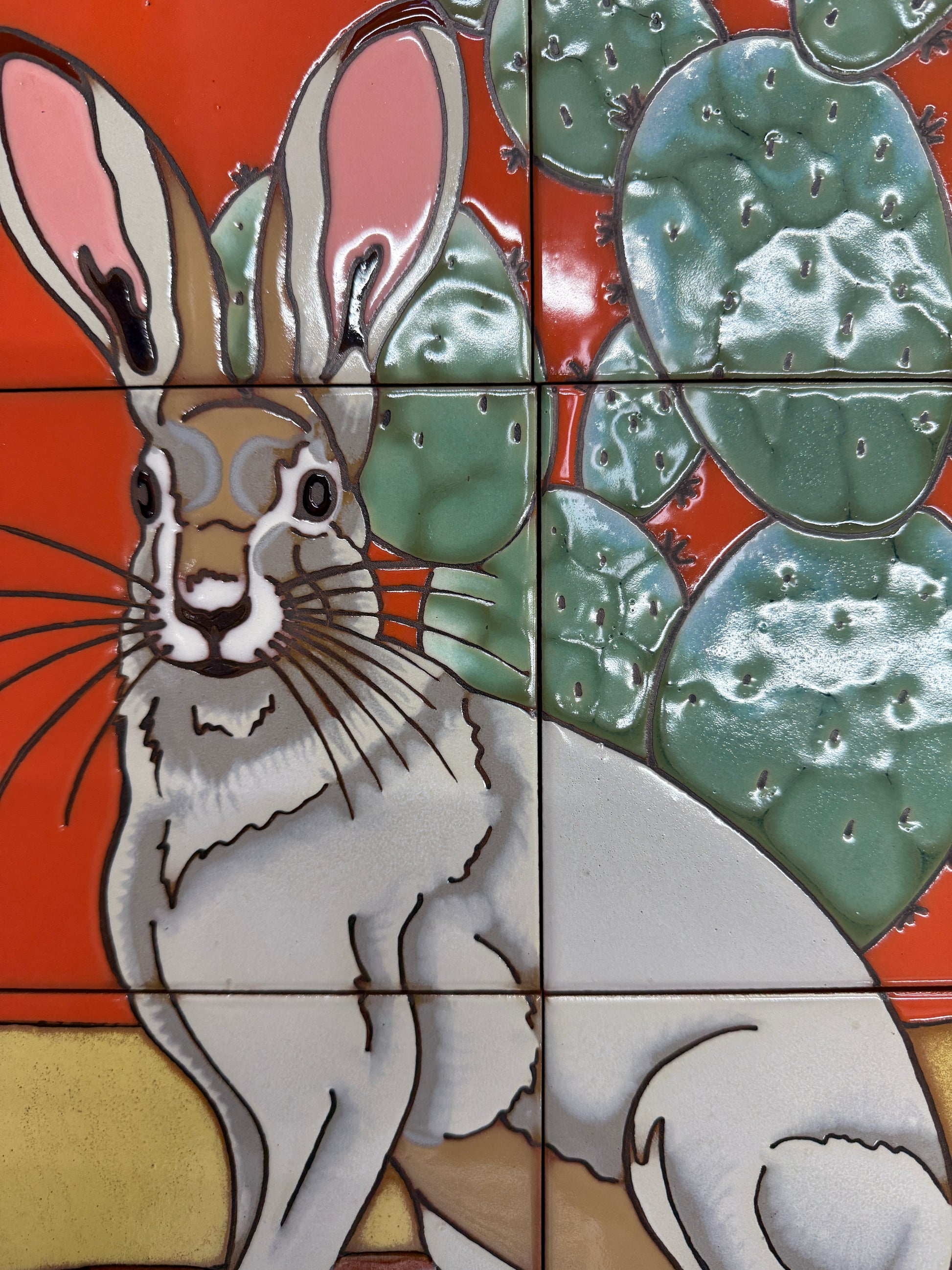 Tile mosaic featuring a stylized rabbit and lily pads on a red background