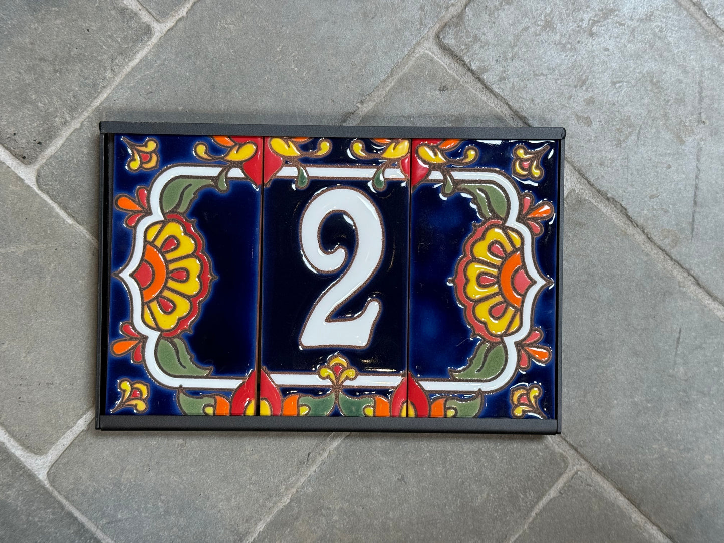 Decorative house number '2' on a colorful tile background