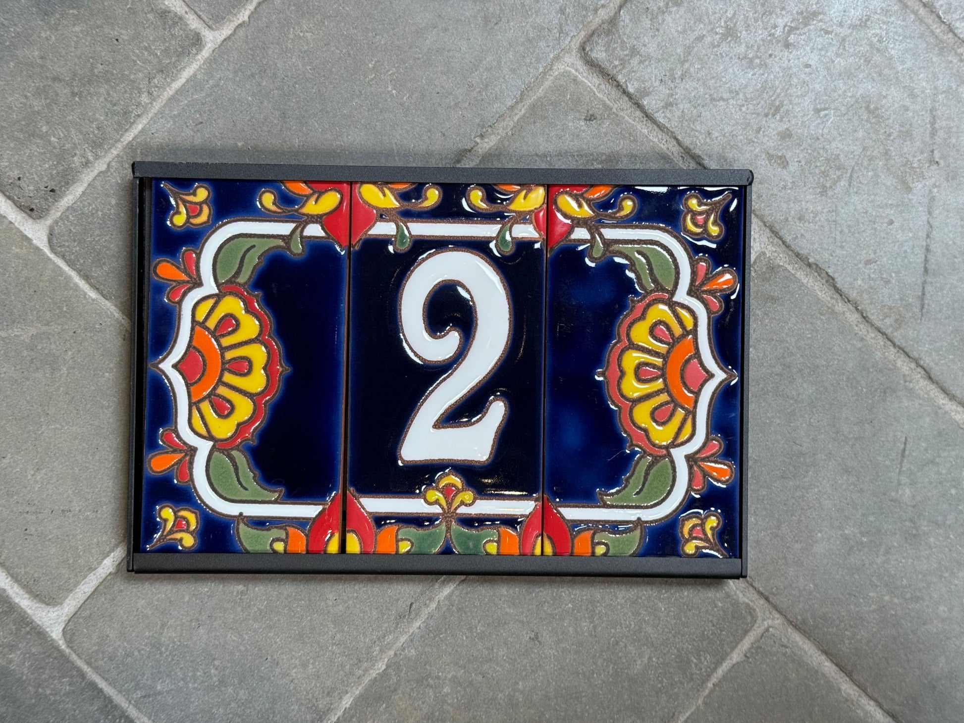 Decorative house number '2' on a colorful tile background
