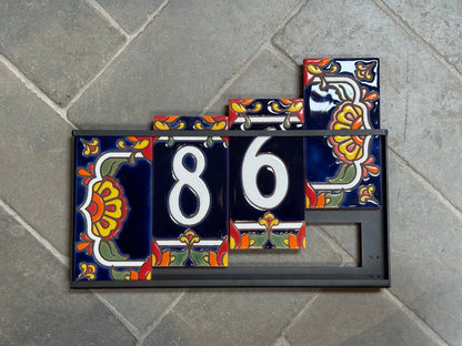 Decorative house number tiles with '86' on a stone pavement background