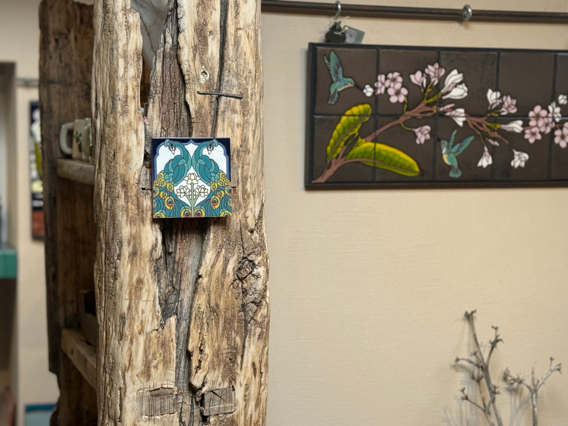 Decorative tiles on a wooden surface and wall with floral and bird design.