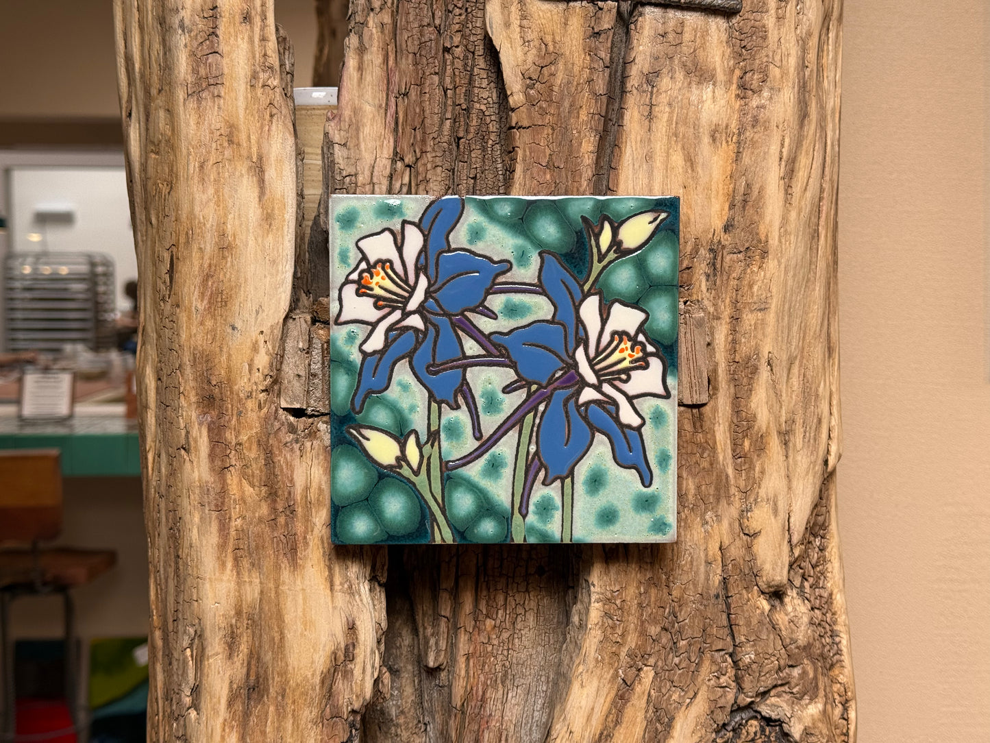 Decorative tile with floral design on a wooden surface