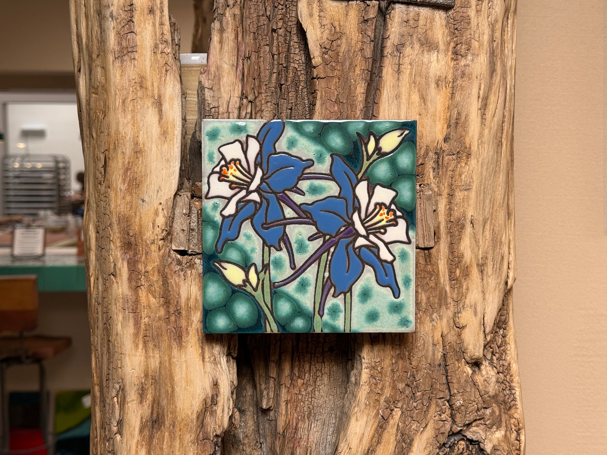 Decorative tile with floral design on a wooden surface
