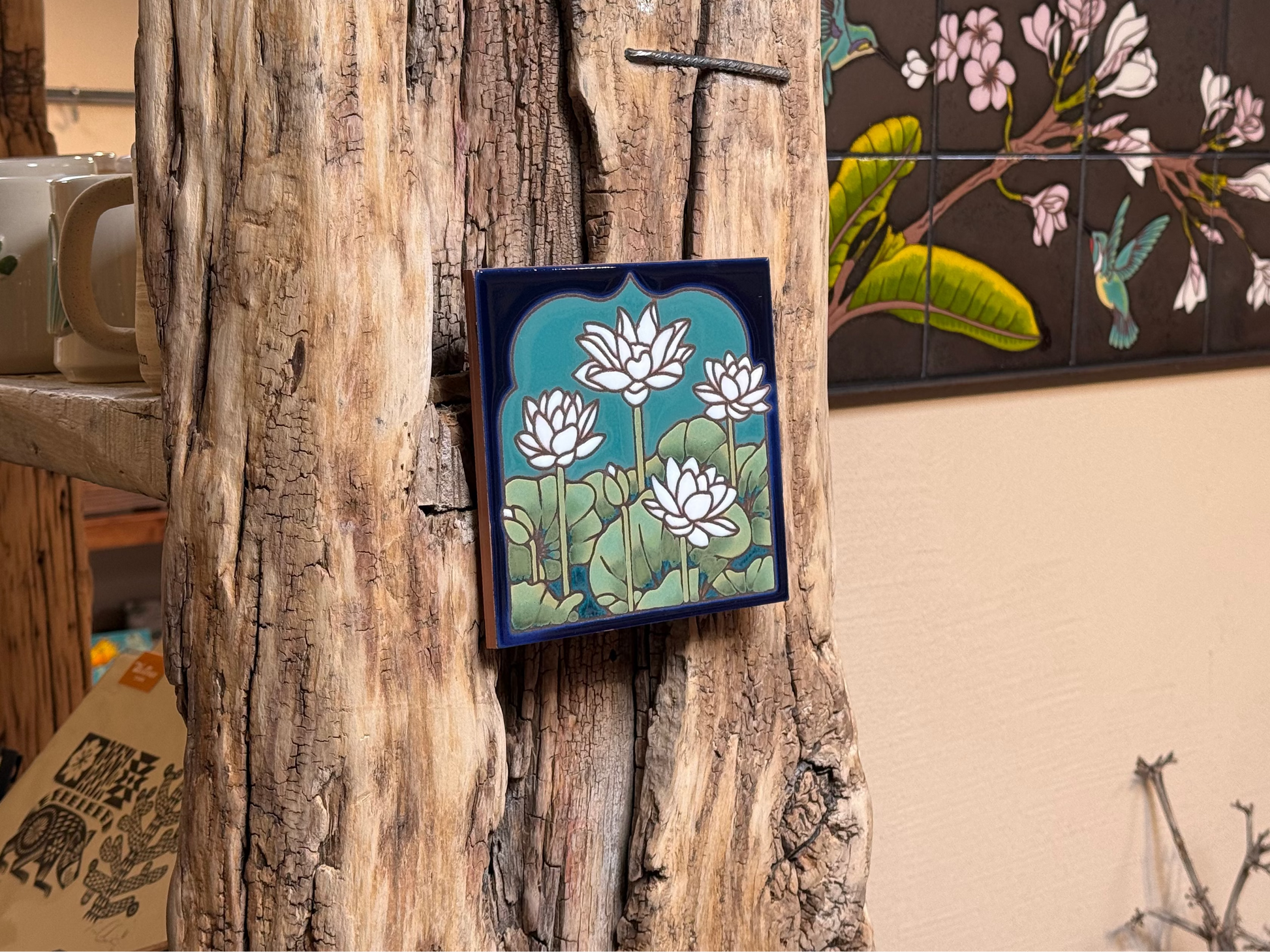 Decorative tiles with floral designs on a wooden surface and wall.
