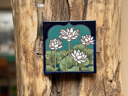 Decorative tile with lotus flower design attached to a wooden surface