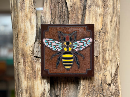 Decorative bee emblem on a wooden surface