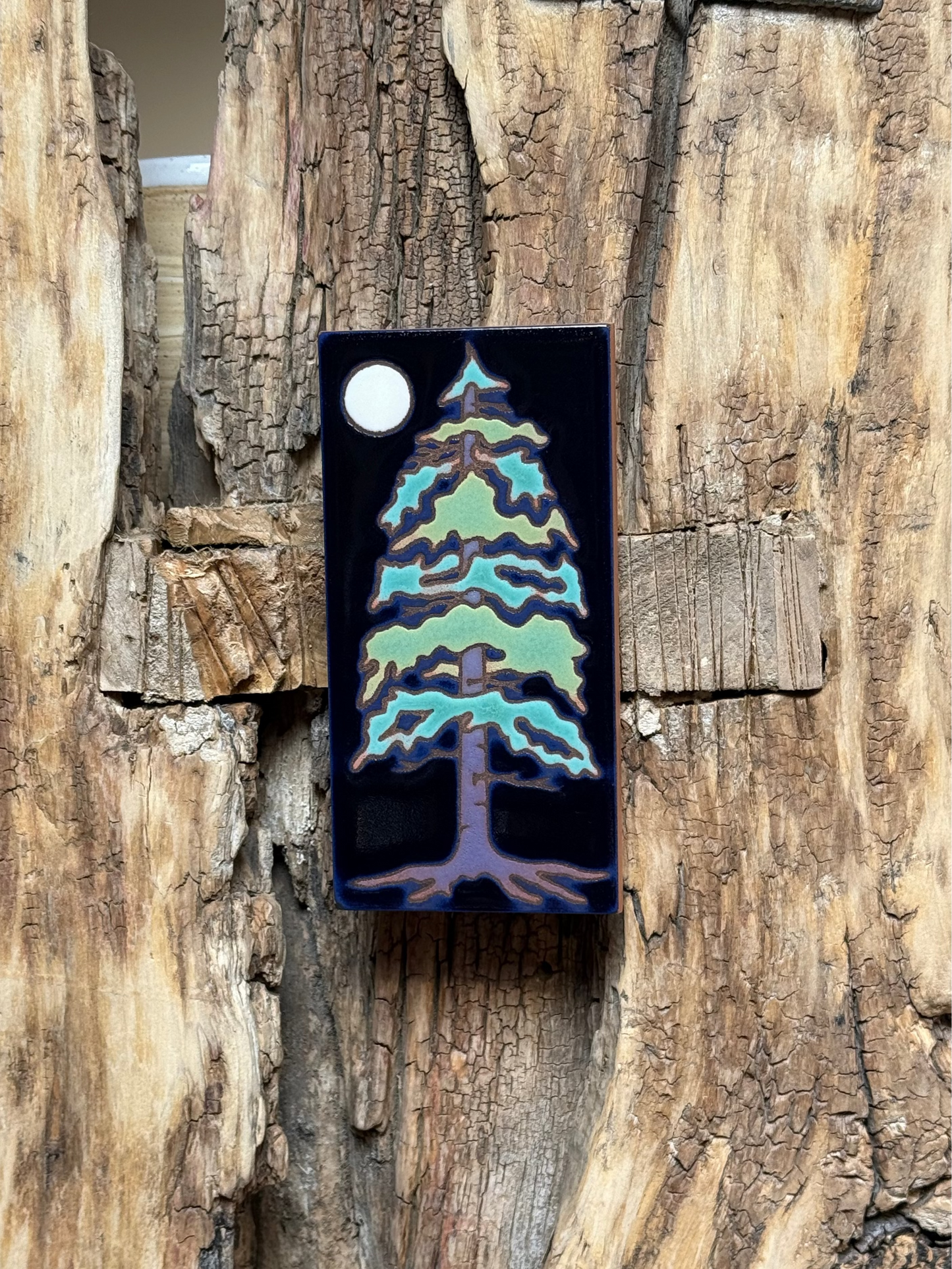 Decorative pine tree ornament on a wooden background