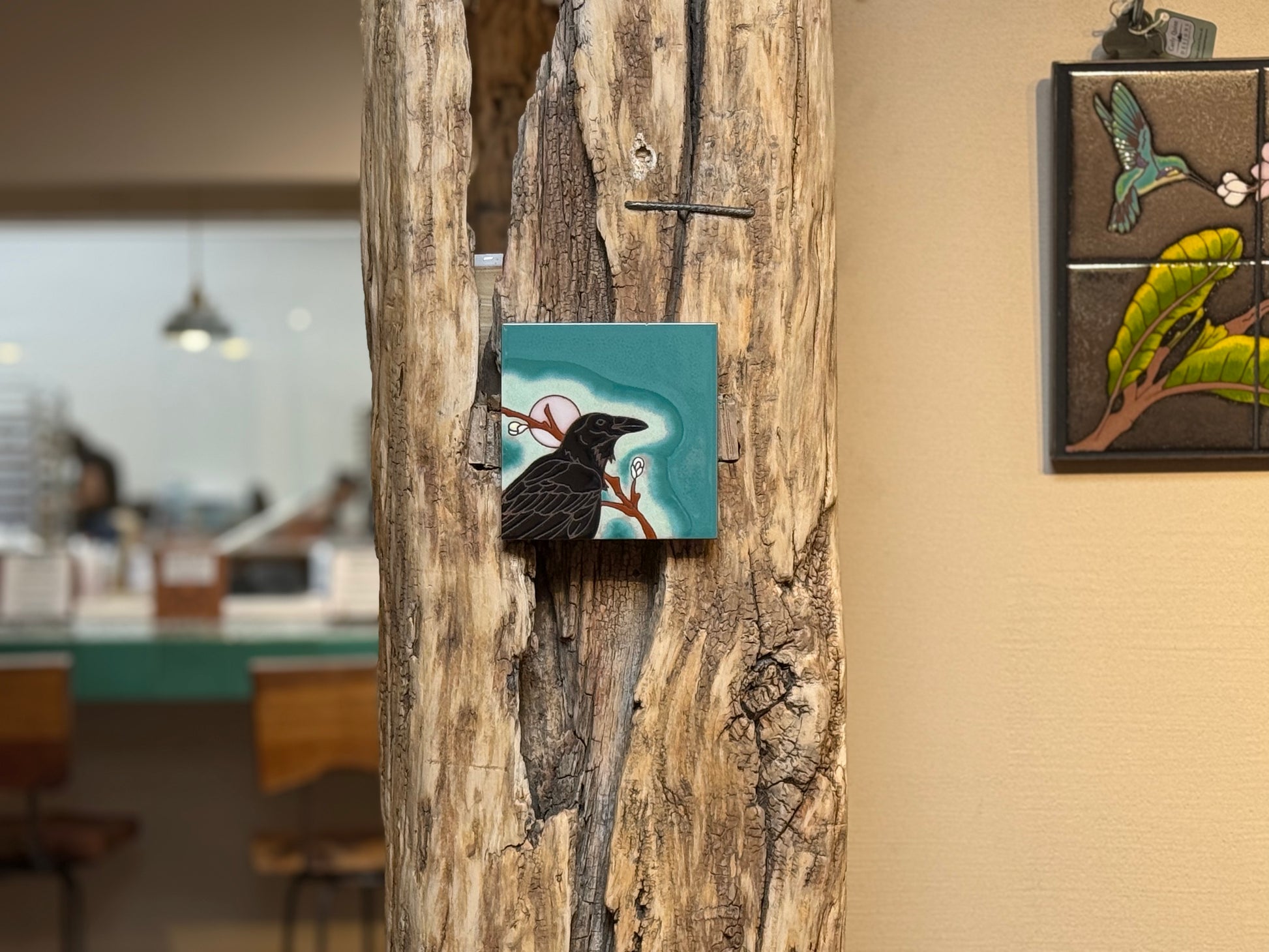 Decorative tiles with nature-themed designs on a wooden wall