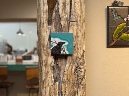 Decorative tiles with nature-themed designs on a wooden wall