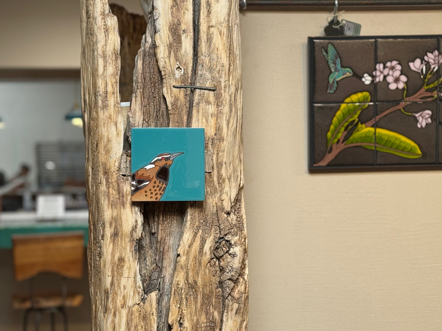 Artistic tiles on a wooden panel and wall with a blurred indoor background
