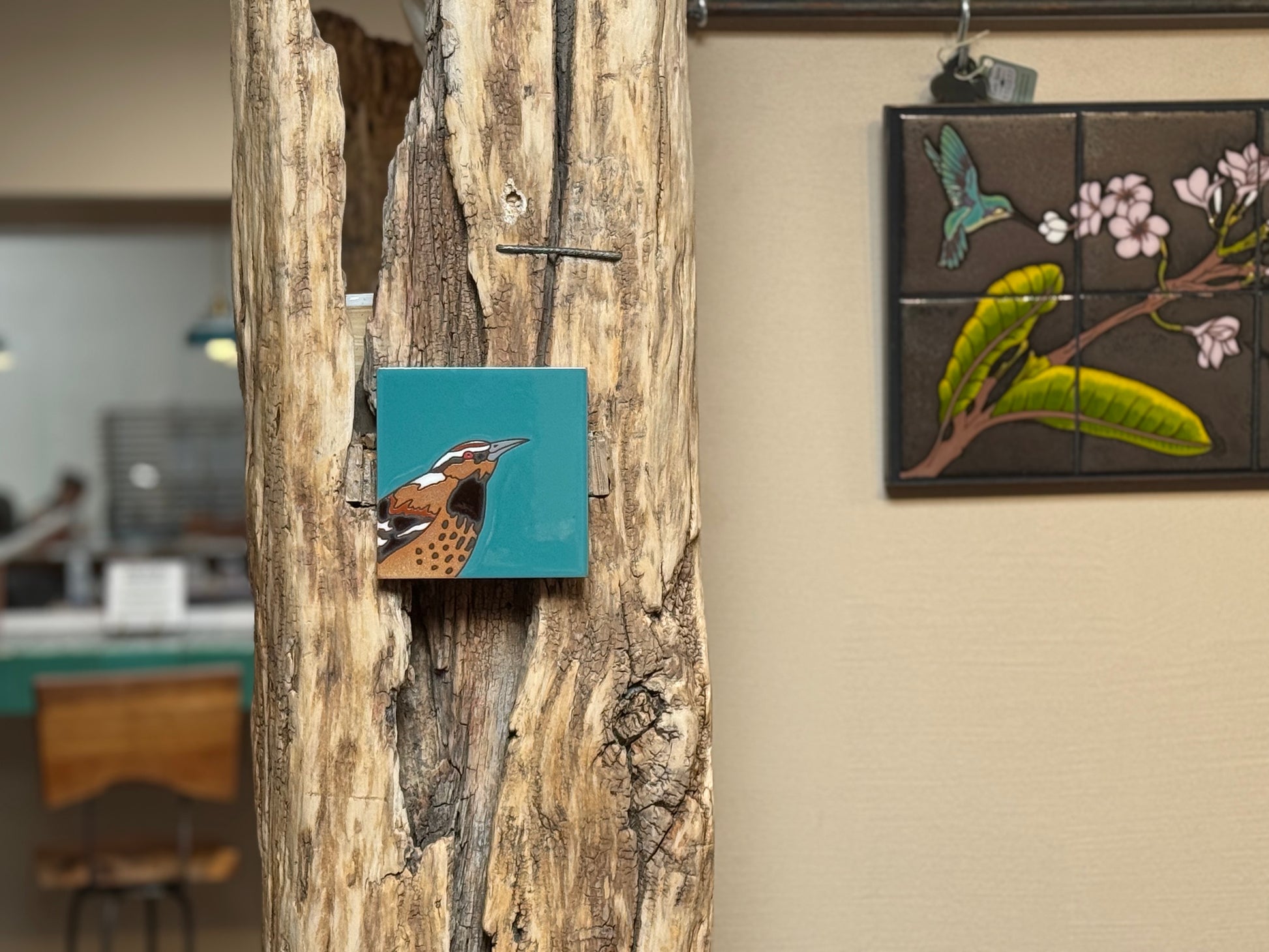 Artistic tiles on a wooden panel and wall with a blurred indoor background