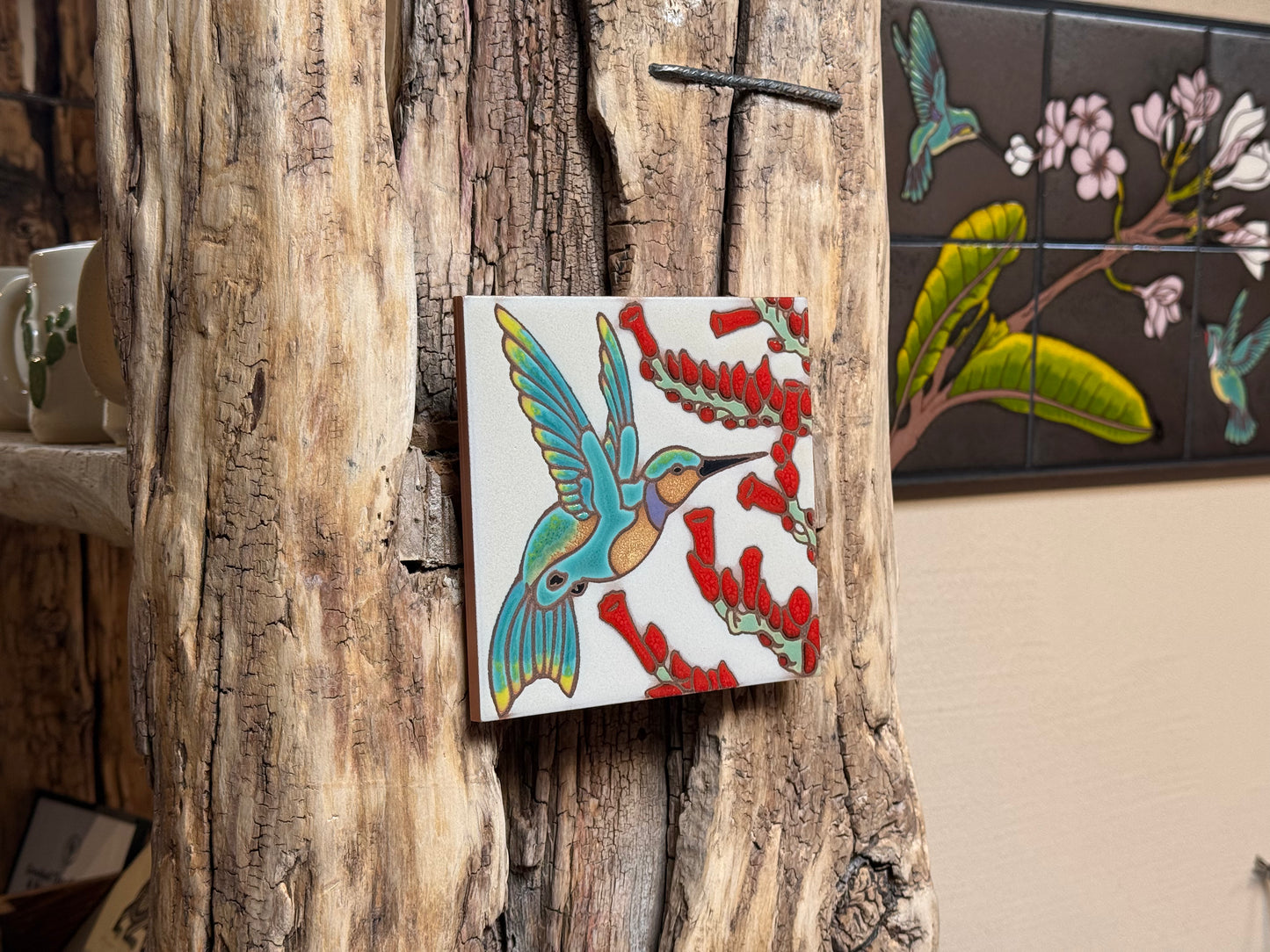 Decorative tile with a colorful bird design on a rustic wooden wall.