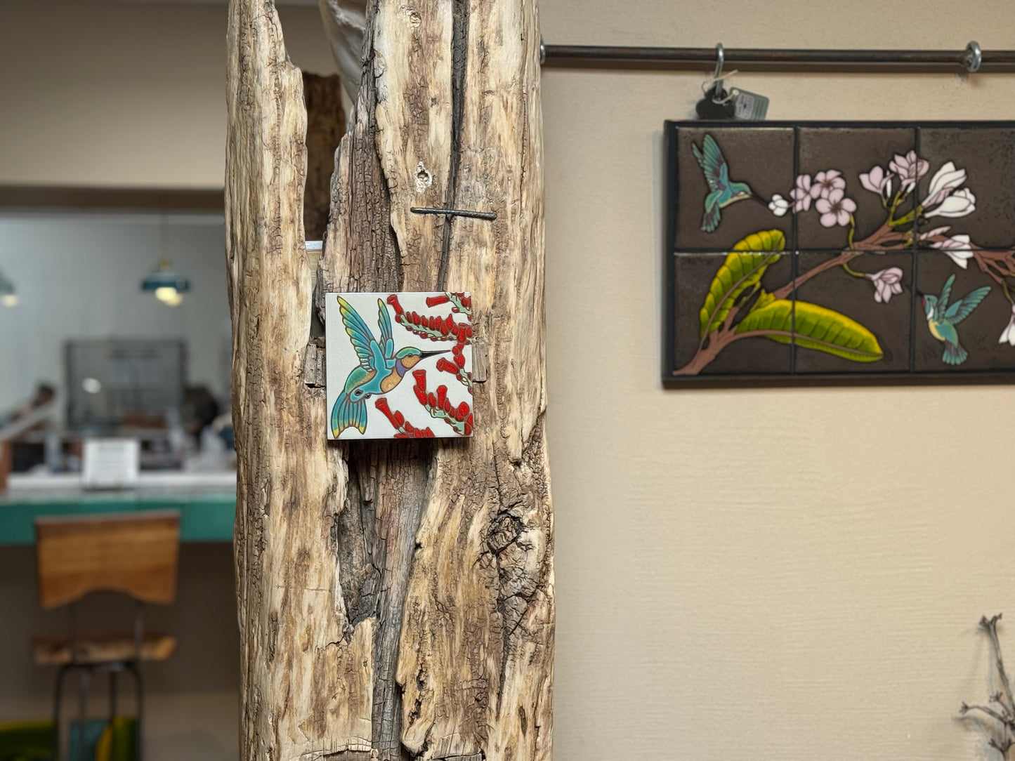 Decorative tiles with bird and floral designs on a wooden post and wall.