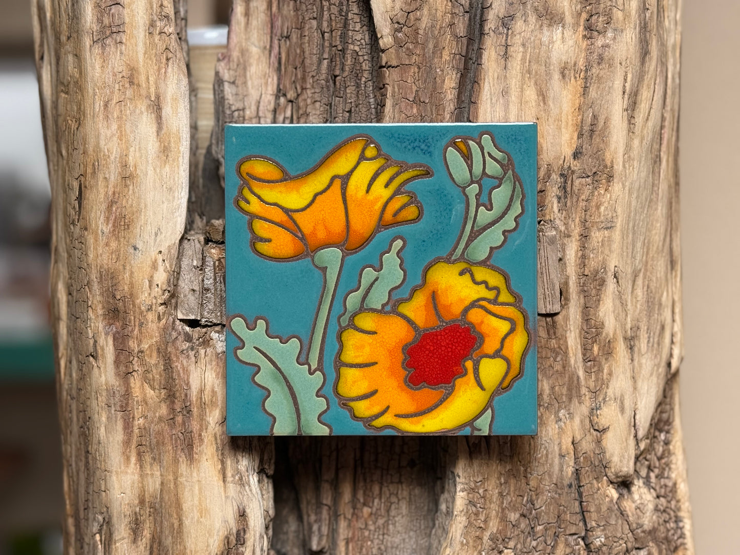 Decorative tile with floral design on a wooden surface