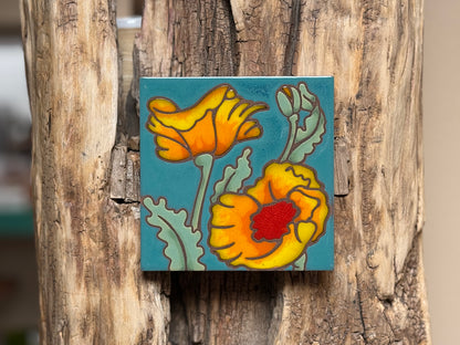 Decorative tile with floral design on a wooden surface