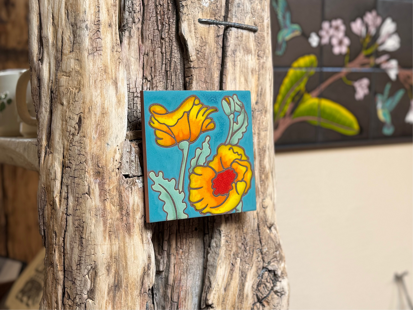 Decorative tile with floral design attached to a wooden surface