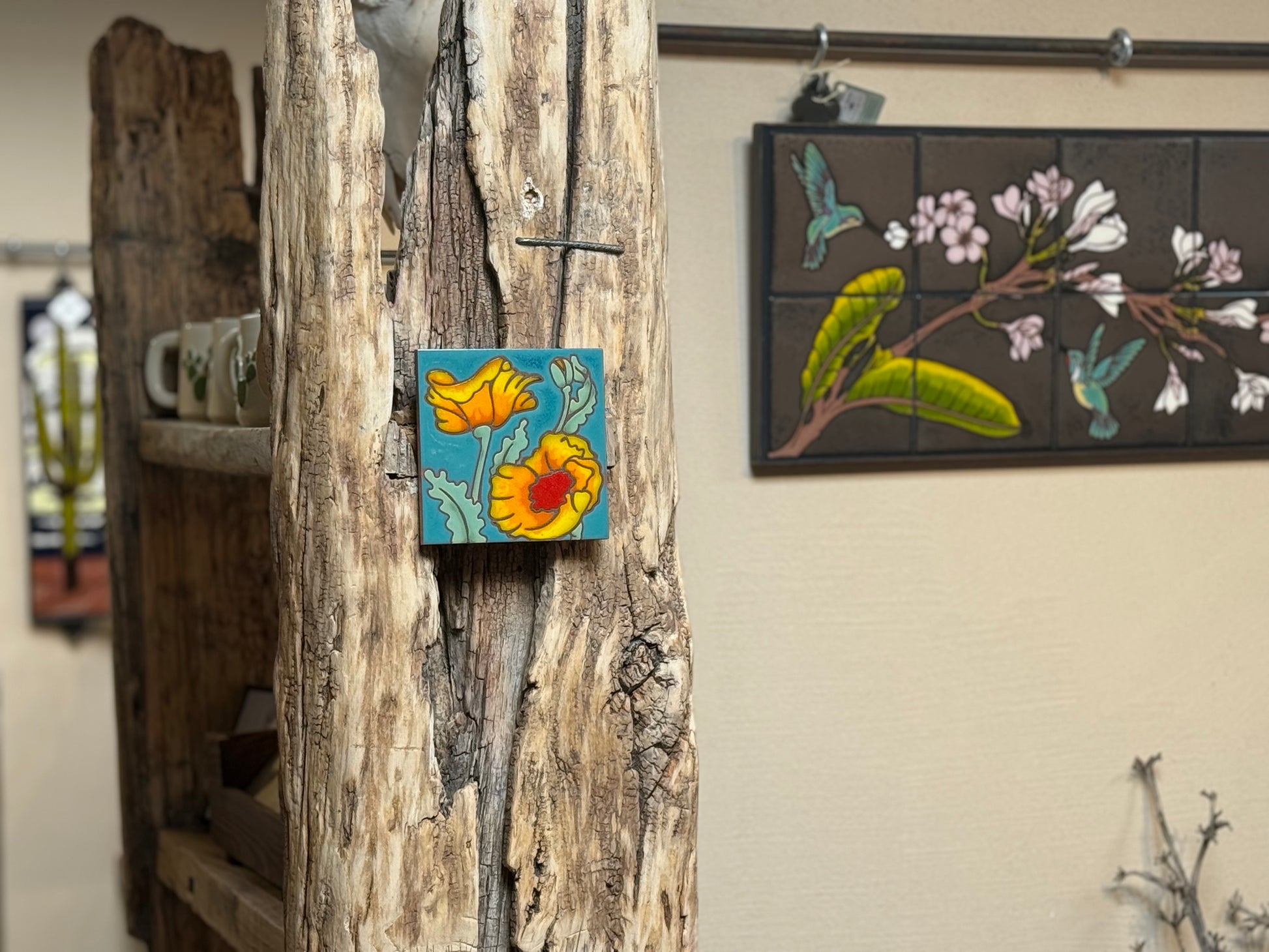 Decorative tiles with floral designs on a wooden surface and wall.