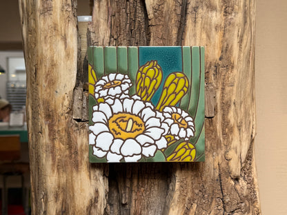 Decorative tile with floral design attached to a wooden surface