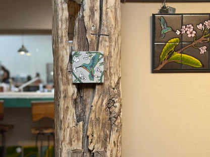 Decorative tiles with bird and floral designs on a wooden post and wall.
