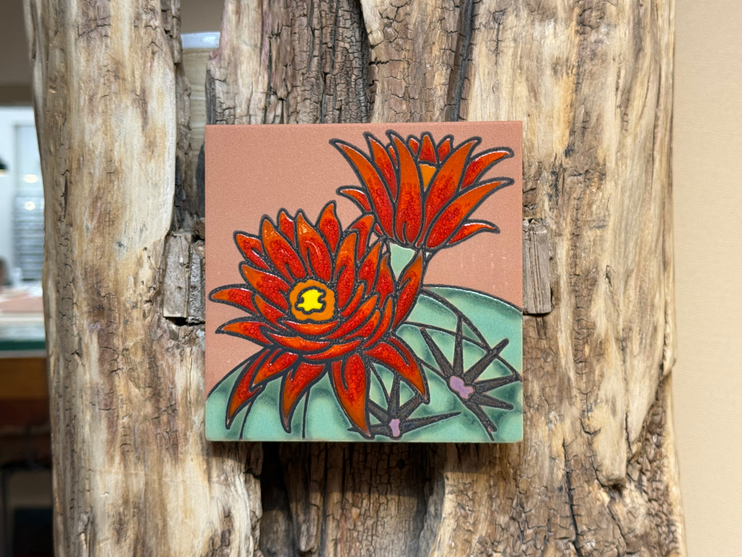 Small painting of red flowers on a wooden surface