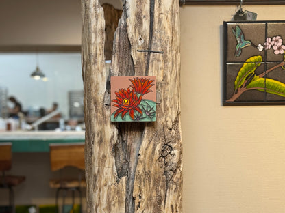 Decorative tiles on a wooden panel with a blurred cafe background