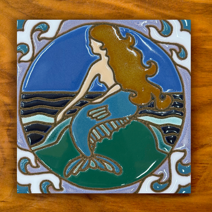 Mermaid ceramic tile on a wooden background