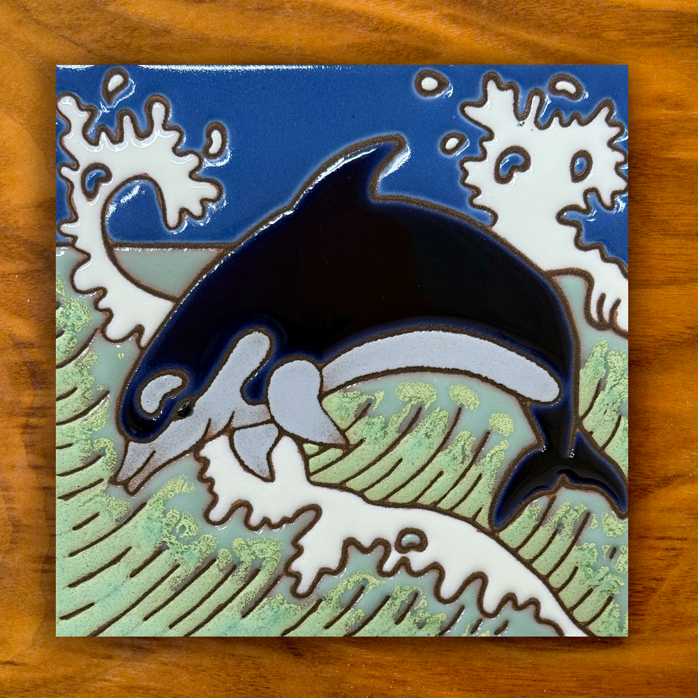 dolphin ceramic tile on a wooden background