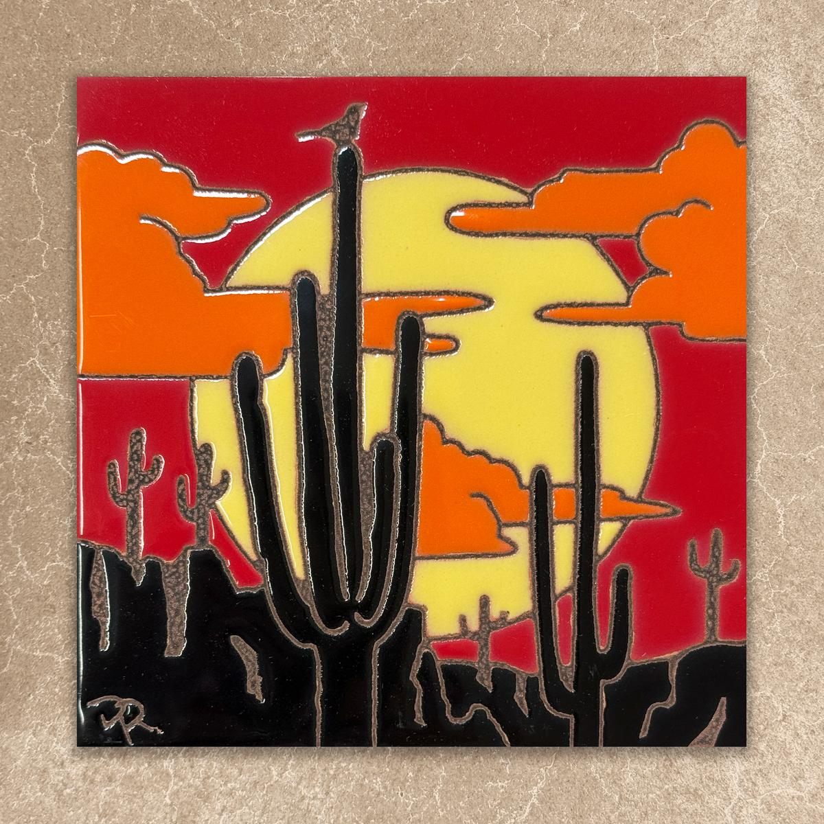 ceramic tile of cacti with a sunset background on a textured surface