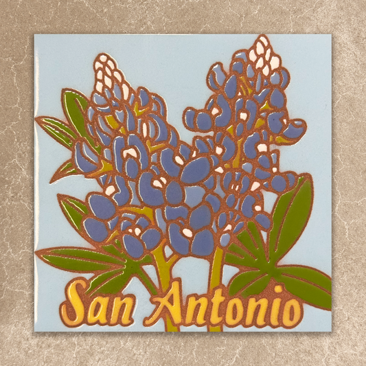 Decorative ceramic tile with bluebonnet flowers and 'San Antonio' text on a light blue background