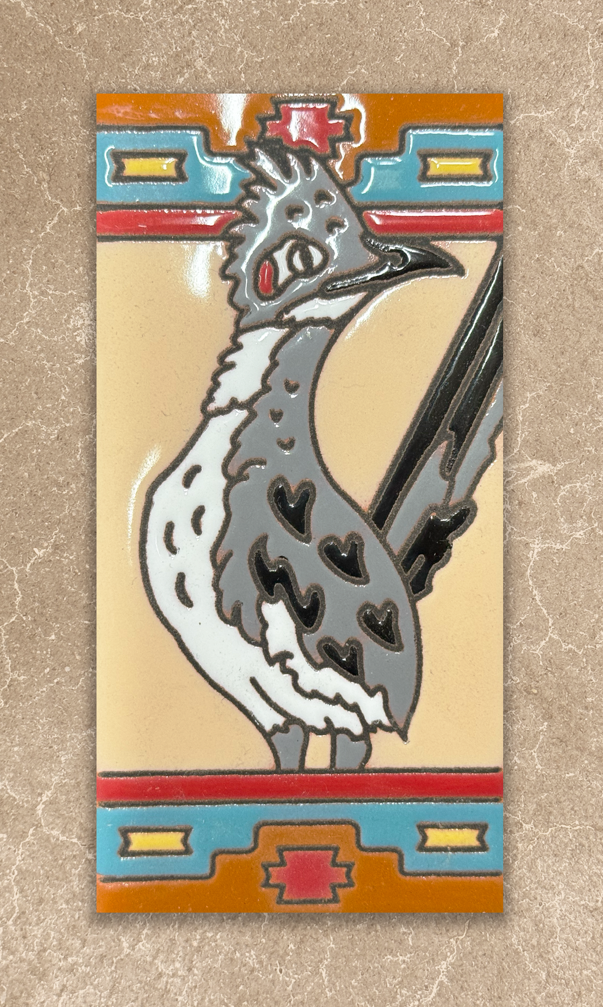 Decorative tile with a stylized bird design on a beige background