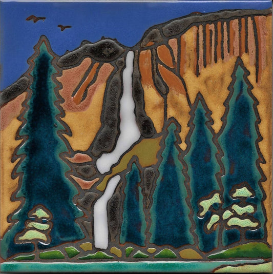 A square ceramic tile featuring a stylized landscape design of a waterfall cascading down a canyon with pine trees under a blue sky.
