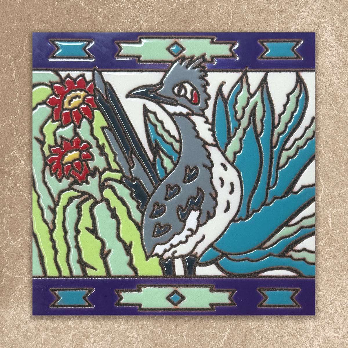 Decorative tile with a bird, cactus, and flower design on a beige background