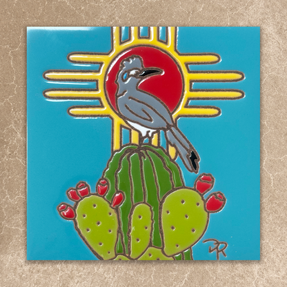 ceramic tile with a bird on a cactus and sun design on a blue background